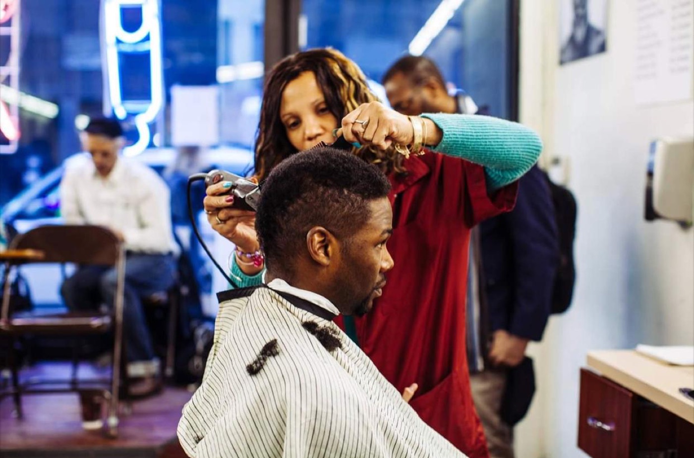 Barber styling client hair in shop
