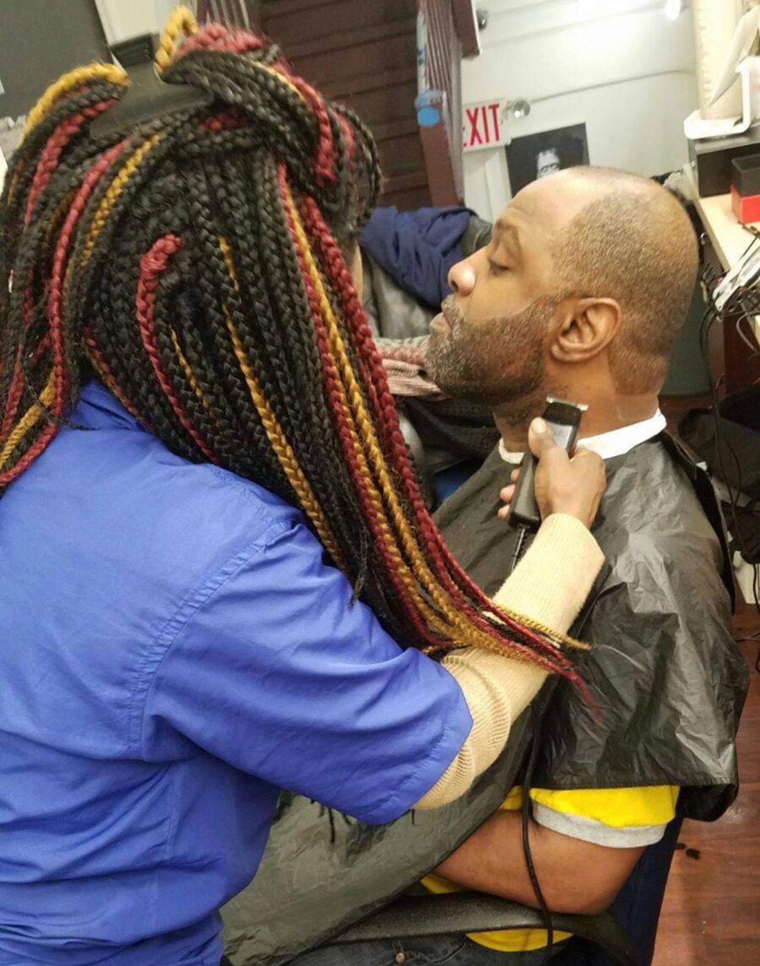 Student trimming client beard upclose