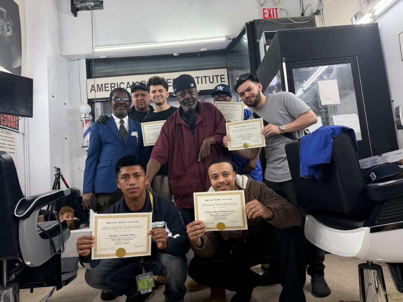 Five graduates holding certificates together